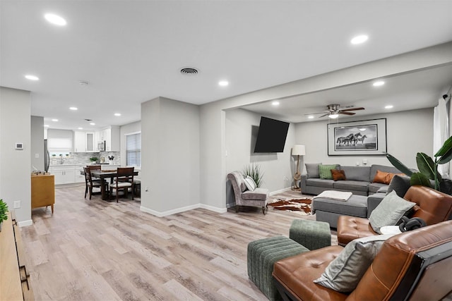 living room featuring ceiling fan and light hardwood / wood-style flooring