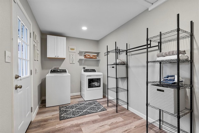 laundry room with cabinets, light hardwood / wood-style floors, and independent washer and dryer