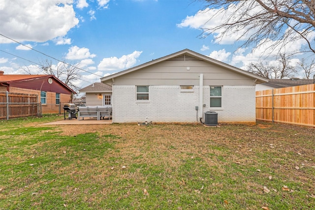 rear view of house with central air condition unit, a patio area, and a yard