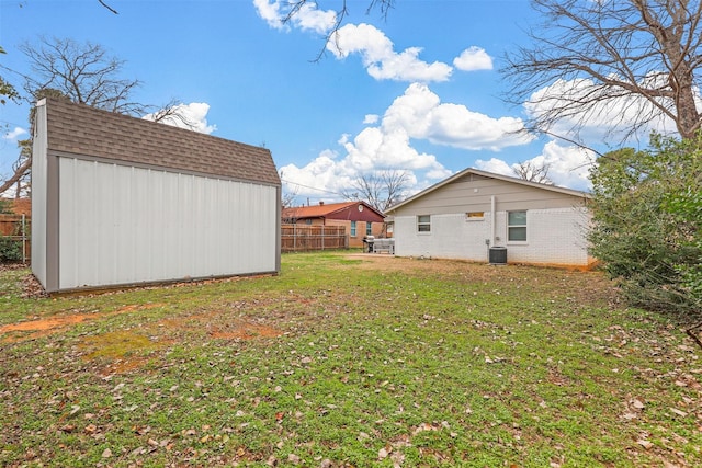 view of yard featuring a shed and central air condition unit