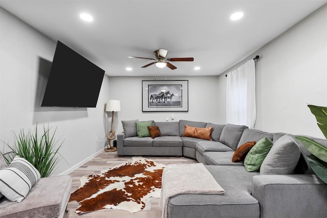 living room featuring light hardwood / wood-style floors and ceiling fan