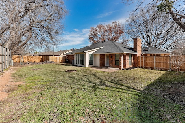 rear view of house with a yard and a patio area