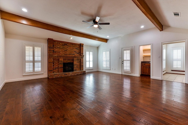 unfurnished living room with a fireplace, lofted ceiling with beams, ceiling fan, and dark wood-type flooring