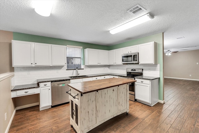 kitchen featuring wood counters, sink, white cabinets, and appliances with stainless steel finishes