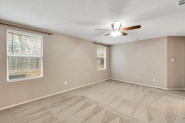 carpeted spare room featuring ceiling fan and a textured ceiling