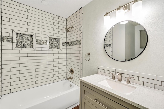 bathroom with tiled shower / bath combo, tasteful backsplash, and vanity