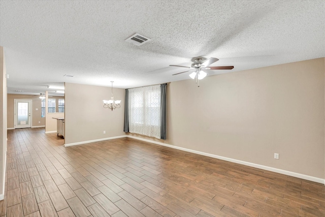 unfurnished room featuring wood-type flooring, ceiling fan with notable chandelier, and a textured ceiling