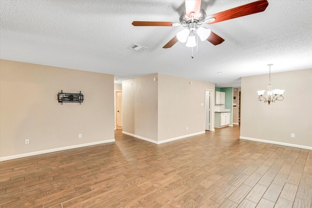 unfurnished room featuring wood-type flooring, ceiling fan with notable chandelier, and a textured ceiling