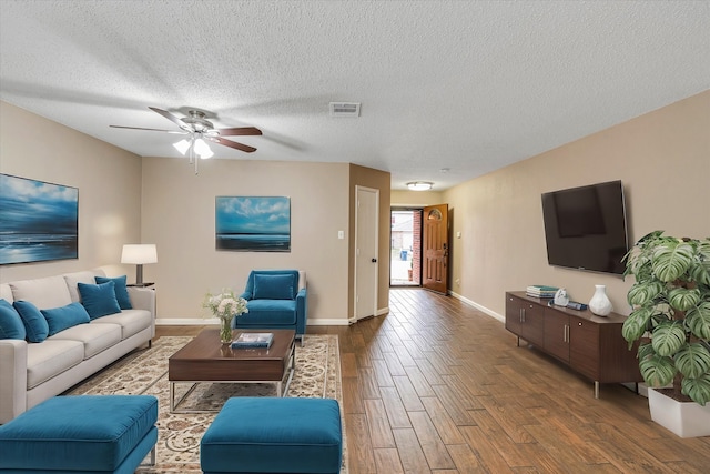 living room with a textured ceiling and ceiling fan