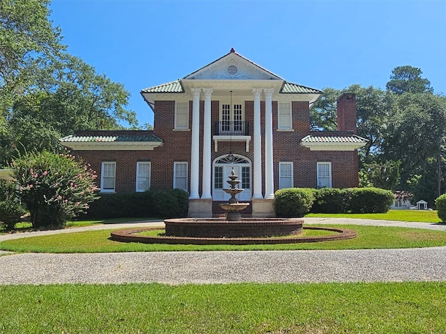 neoclassical home with a front lawn