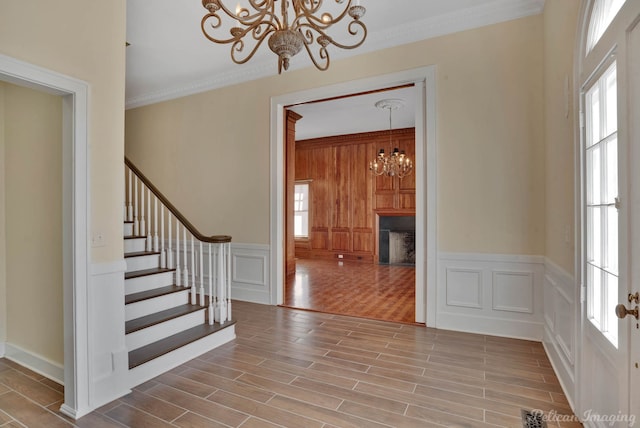 foyer with crown molding, a healthy amount of sunlight, and a chandelier