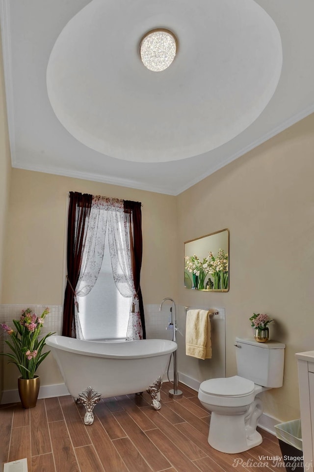 bathroom featuring toilet, ornamental molding, and a bath