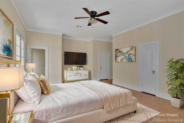 bedroom with crown molding, light hardwood / wood-style floors, and ceiling fan