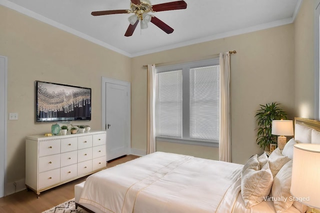 bedroom with crown molding, ceiling fan, and light hardwood / wood-style floors