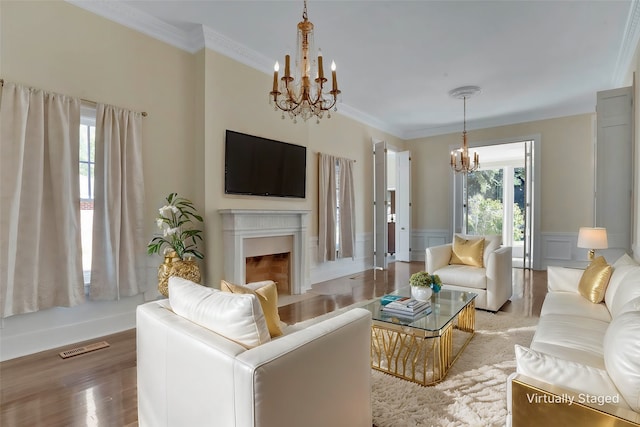 living room with ornamental molding, hardwood / wood-style floors, and a notable chandelier