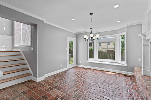 unfurnished dining area featuring a notable chandelier, crown molding, and a healthy amount of sunlight