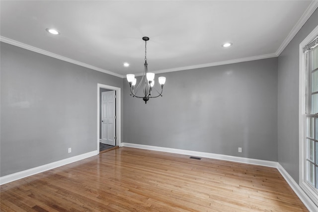 unfurnished room featuring light wood-type flooring, crown molding, and a chandelier