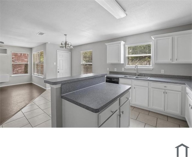 kitchen featuring sink, white cabinetry, a center island, and light tile patterned floors