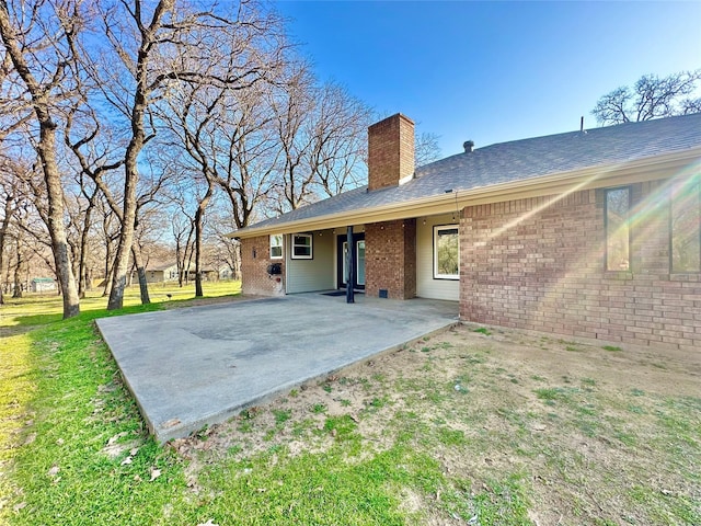 back of house with a patio and a lawn