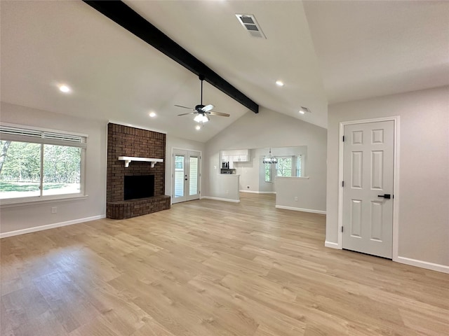 unfurnished living room featuring ceiling fan with notable chandelier, a brick fireplace, light wood-type flooring, and vaulted ceiling with beams