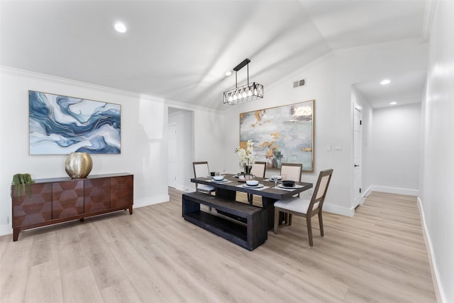 dining space with lofted ceiling, ornamental molding, and light hardwood / wood-style flooring