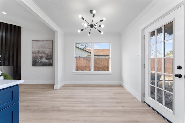 unfurnished dining area featuring a notable chandelier, light wood-type flooring, and ornamental molding