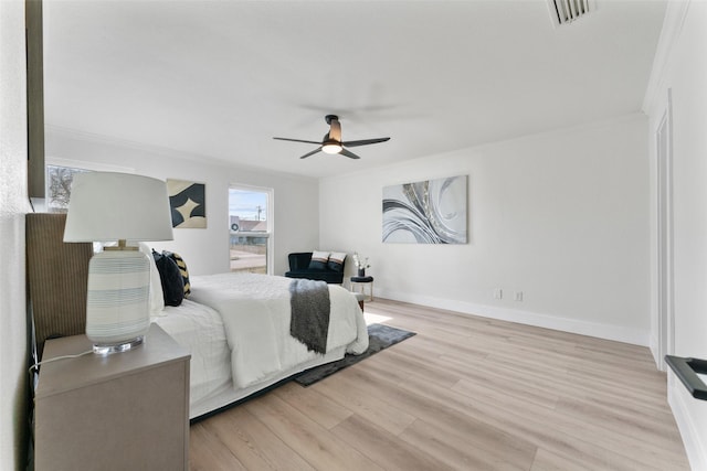 bedroom featuring ceiling fan, light wood-type flooring, and crown molding