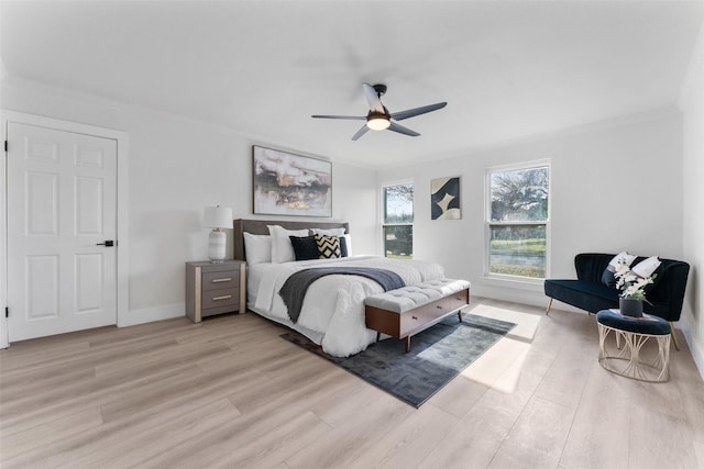 bedroom with ceiling fan, crown molding, and light hardwood / wood-style flooring