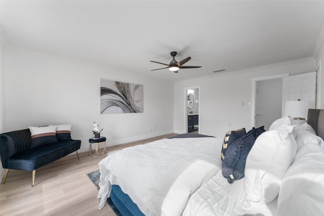 bedroom featuring ceiling fan, ensuite bath, light hardwood / wood-style floors, and crown molding