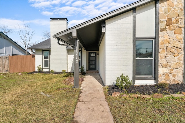 doorway to property featuring a lawn