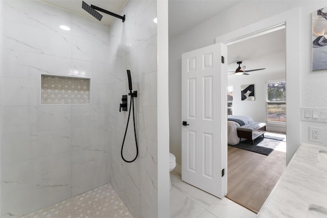 bathroom with toilet, tiled shower, ceiling fan, and hardwood / wood-style floors