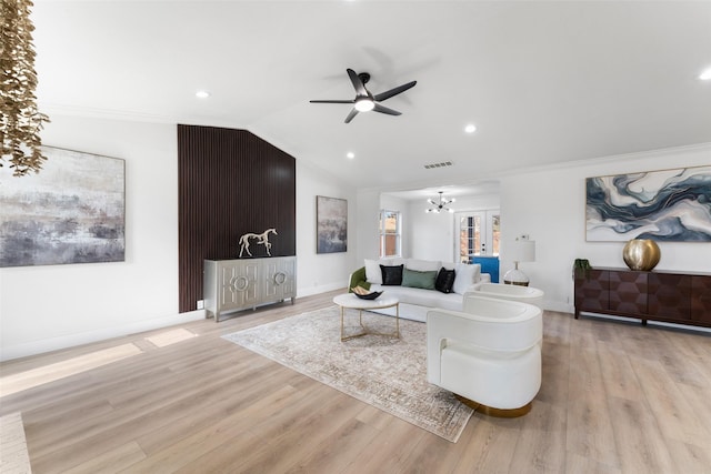 living room featuring ceiling fan with notable chandelier, lofted ceiling, and light hardwood / wood-style floors