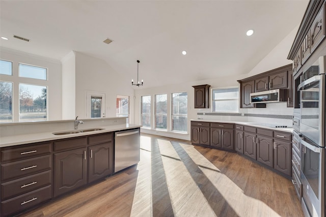 kitchen featuring decorative light fixtures, an inviting chandelier, dark brown cabinetry, and appliances with stainless steel finishes