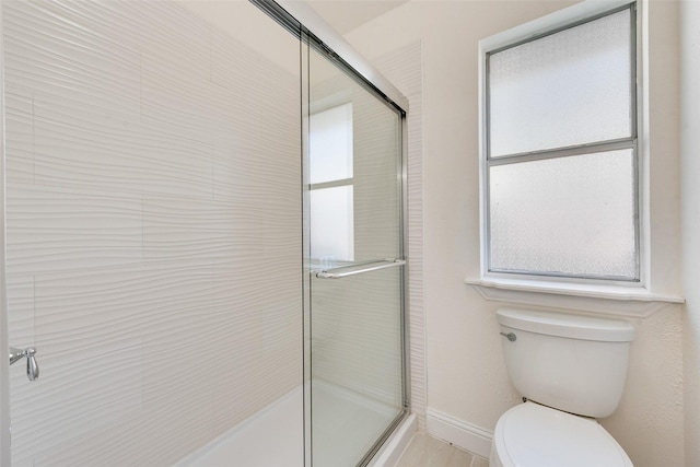 bathroom featuring toilet and a shower with door