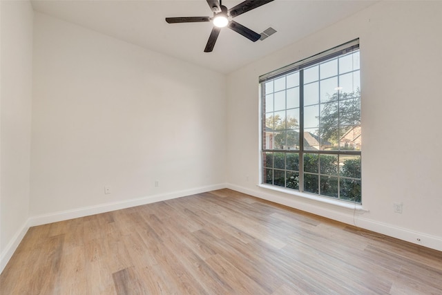 empty room featuring light hardwood / wood-style floors, ceiling fan, and a wealth of natural light