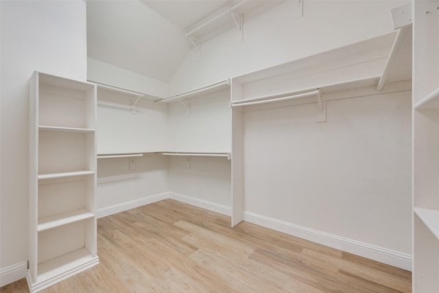 spacious closet with light wood-type flooring and lofted ceiling