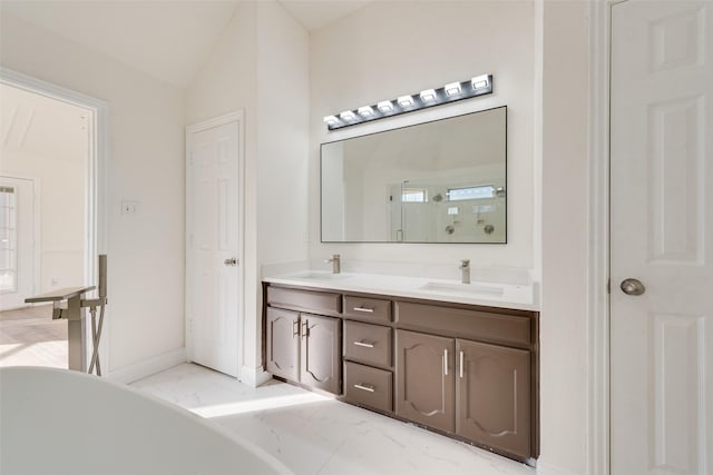 bathroom with a tub, lofted ceiling, and vanity