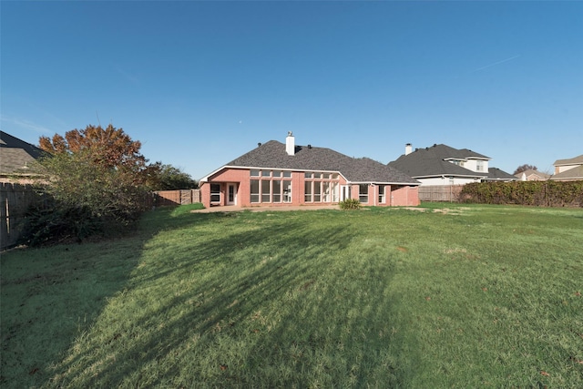 rear view of house with a yard