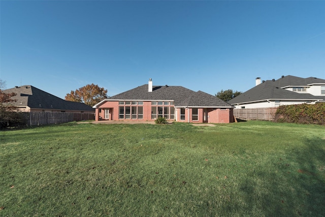 rear view of property with a lawn