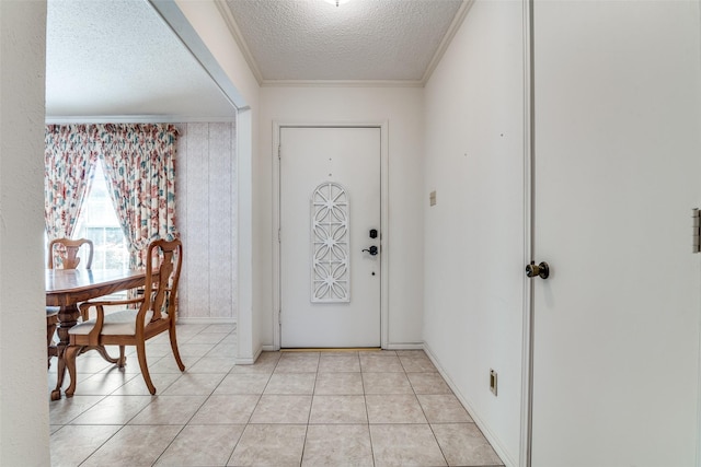 entrance foyer featuring a textured ceiling, light tile patterned flooring, baseboards, and crown molding