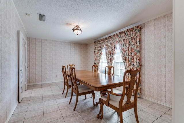 dining space with visible vents, a textured ceiling, and light tile patterned floors