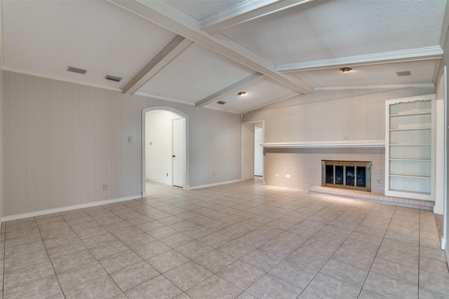 unfurnished living room with lofted ceiling with beams, arched walkways, a textured ceiling, and a glass covered fireplace