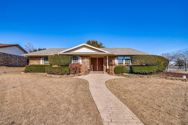 single story home featuring roof with shingles and brick siding