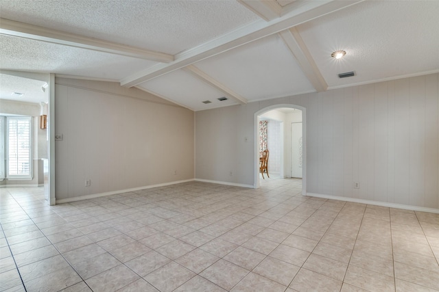 spare room with arched walkways, light tile patterned flooring, vaulted ceiling with beams, and a textured ceiling