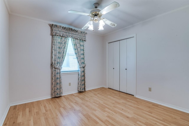 unfurnished bedroom with a ceiling fan, baseboards, ornamental molding, a closet, and light wood-type flooring