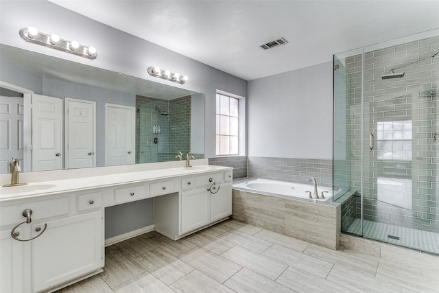 full bath featuring a garden tub, a sink, visible vents, a shower stall, and double vanity