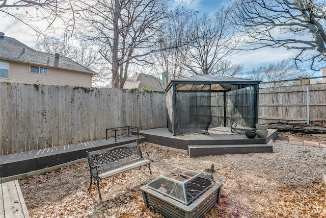 view of yard with a fire pit, a gazebo, a fenced backyard, and a wooden deck