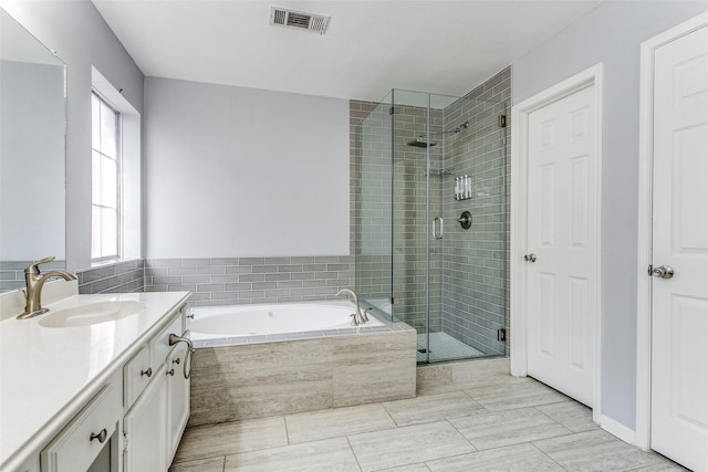 bathroom with a stall shower, visible vents, a garden tub, and vanity