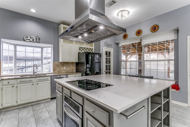 kitchen featuring a sink, a kitchen island, visible vents, black appliances, and island exhaust hood