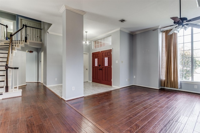 entryway with wood finished floors, visible vents, baseboards, ornamental molding, and stairway